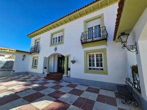 uma grande casa branca com um pátio em azulejo em La casa del árbol em Fuentidueña de Tajo