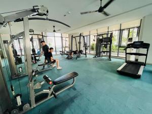 a man and a boy in a gym with machines at Pleasant and Cozy 3BR Suit @ R&F Mall Johor Bahru in Johor Bahru