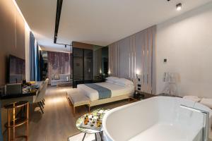 a bedroom with a bed and a tub in a room at Agra Suites in Naples