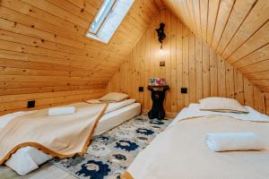 twee bedden in een kamer met houten wanden bij Mountain Base - Dom Hrabiego - AC in Zakopane
