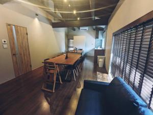 a dining room with a table and a couch at LOOP-shiso 宍粟市BBQとサウナでととのう天空回廊にたたずむ貸別荘 in Shiso