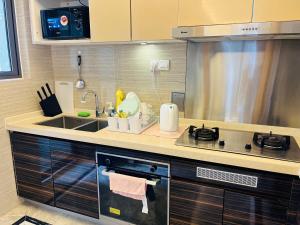 a kitchen with a sink and a stove at Pleasant and Cozy 3BR Suit @ R&F Mall Johor Bahru in Johor Bahru