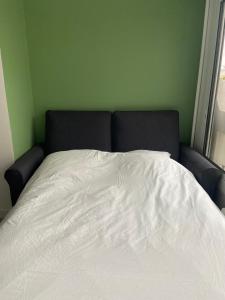 uma cama num quarto com um edredão branco em Studio vue sur Seine em Rouen