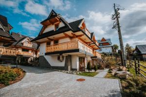 a wooden house with a balcony on a street at Mountain Base - Dom Hrabiego in Zakopane