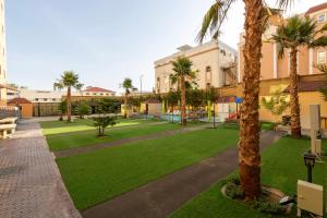 a park with palm trees and a building at زمان هوم لاند Zaman Homeland in Taif