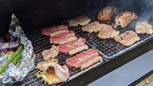 a grill with different types of meat and vegetables at Mount Fuji Panorama Glamping in Fujikawaguchiko