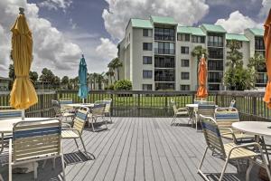 an outdoor patio with tables and chairs and umbrellas at Ocean Village Condo 3 Pools, Hot Tub and Beach in Fort Pierce