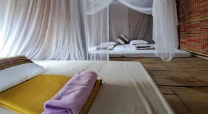 um quarto com 2 camas e cortinas brancas em Muong Bi Homestay em Hòa Bình