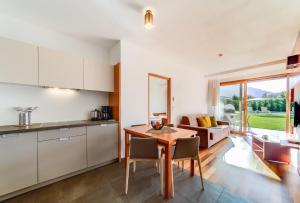 eine Küche und ein Wohnzimmer mit einem Tisch und Stühlen in der Unterkunft Residence & Sportlodges Claudia in Plaus
