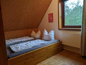 łóżko w pokoju z oknem w obiekcie Ferienhaus Waldschlösschen w mieście Gelting