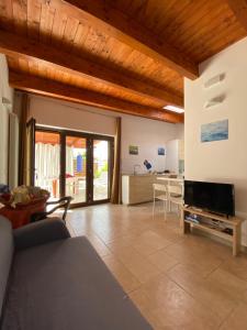 een woonkamer met een bank en een televisie bij Il Giardino dei Limoni - Leporano Marina (TA) in Leporano Marina