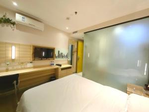 1 dormitorio con 1 cama blanca grande y TV en 上下九城市快捷酒店 en Cantón