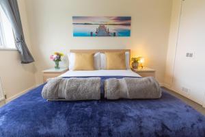 - une chambre avec un grand lit et un tapis bleu dans l'établissement ZSKstays! Comfortable home, nice area, free parking and large garden!, à Hull