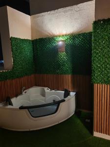 y baño con bañera y paredes verdes. en Cordoba Suites en Hurghada