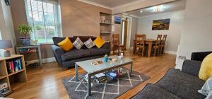 a living room with two couches and a table at Inverour Guest House in Spean Bridge