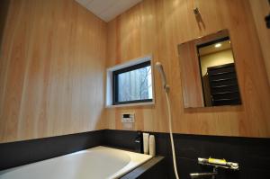 łazienka z wanną, oknem i umywalką w obiekcie Wakakusa-an w mieście Kioto
