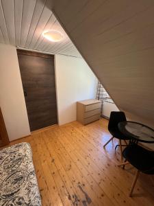 a attic room with a door and a table and chairs at Willa Zacisze Karpacz in Karpacz