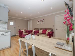 a kitchen and living room with a large wooden table at Myrtle Cottage in Cardiff
