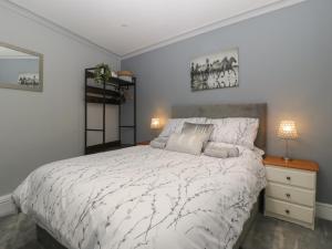 a bedroom with a bed with a white comforter at Myrtle Cottage in Cardiff