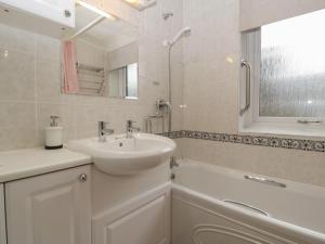 a white bathroom with a sink and a bath tub at Myrtle Cottage in Cardiff +17 photos