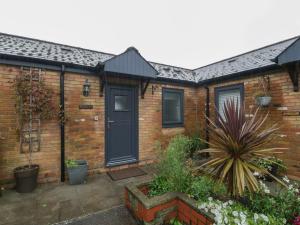 a brick house with a black door at Myrtle Cottage in Cardiff
