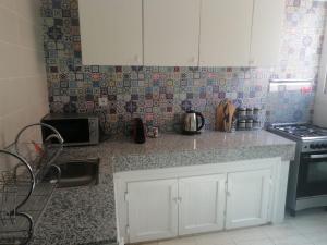 a kitchen with white cabinets and a counter top at Appartement gueliz de luxe in Marrakesh