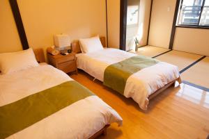 sypialnia z 2 łóżkami i telewizorem w obiekcie Wakakusa-an w mieście Kioto