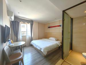 Habitación de hotel con cama, mesa y escritorio. en 上下九城市快捷酒店 en Cantón