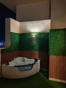 a bath tub in a room with green walls at Cordoba Suites in Hurghada