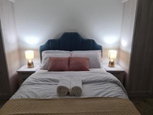 a bed with two books on it with two lamps at Sky's Haven in Sunningwell