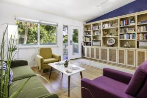 a living room with purple furniture and bookshelves at Dancing Dolphin in Captiva