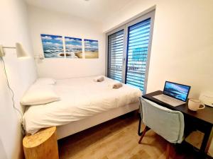 Schlafzimmer mit einem Bett und einem Schreibtisch mit einem Laptop in der Unterkunft Luxury 1bedroom with Parking In Center&Large Terrace -CD3 in Luxemburg (Stadt)