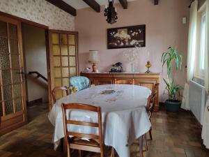 una sala da pranzo con tavolo e sedie bianchi di Villa Amarante ad Annonay