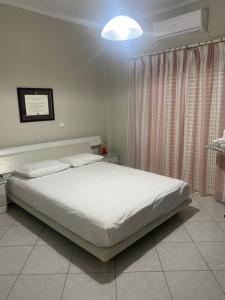 sypialnia z białym łóżkiem i lampką w obiekcie Chalkida Beautiful Home with Stunning Views w Chalkidzie