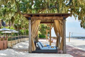 a gazebo with a blue couch under a tree at Grand Hotel Golf Resort & Spa, Autograph Collection in Point Clear