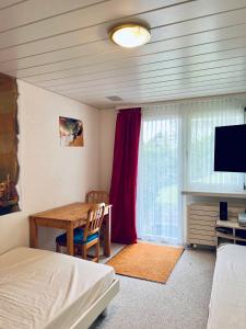 a bedroom with a table and a bed and a television at Casa Lilly - CharmingStay in Flumserberg