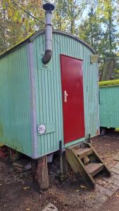 einem grünen Zugwagen mit roter Tür auf einem Stumpf in der Unterkunft Forsthaus Leiner Berg in Dessau