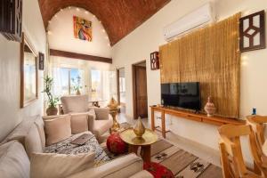 a living room with a couch and a tv at Makadi Heights Elite Residence - Hurghada, Red Sea in Hurghada