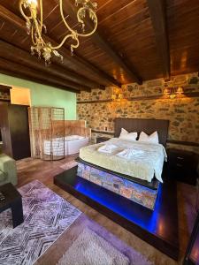 sypialnia z łóżkiem i żyrandolem w obiekcie Suites Mouses w mieście Palaios Agios Athanasios