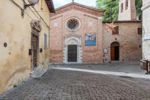 un vieux bâtiment en briques avec une porte dans une rue dans l'établissement Urbino Historical Central Studio!, à Urbino