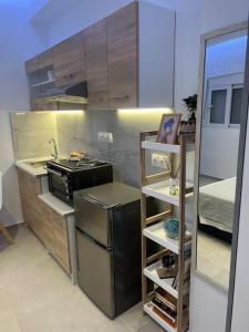 a kitchen with a black refrigerator and a stove at Ikarus Rhodes Center in Rhodes Town