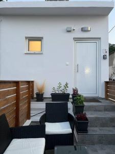 a patio with chairs and a door with potted plants at Ikarus Rhodes Center in Rhodes Town