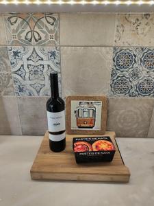 a bottle of wine next to a box of tomatoes at Lx Factory Apartment-Lisbon Style-Spacious & Bright-Congress Centre in Lisbon