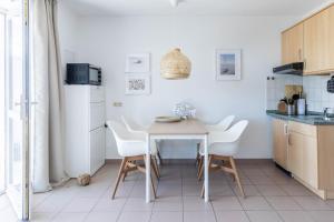 a kitchen with a white table and white chairs at Haus Seeblick Wohnung 12 Easy Ocean in Wohlenberg