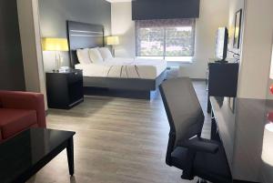 a small hotel room with a bed and a couch at La Quinta Inn & Suites by Wyndham Tulsa Midtown in Tulsa