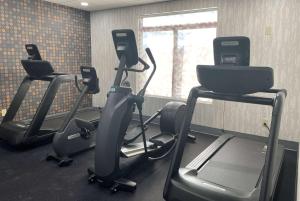 a gym with three tread machines and a window at La Quinta Inn & Suites by Wyndham Tulsa Midtown in Tulsa
