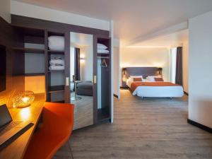 a bedroom with a bed and a large mirror at Novotel La Grande Motte Golf in La Grande Motte