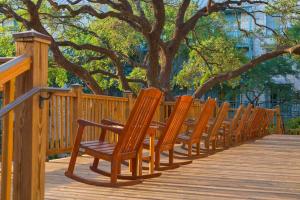 a row of wooden chairs sitting on a wooden deck at Hyatt Regency Hill Country Resort & Spa in San Antonio