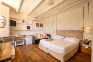 a bedroom with a white bed and a desk at Masseria Bandino & Spa in Otranto