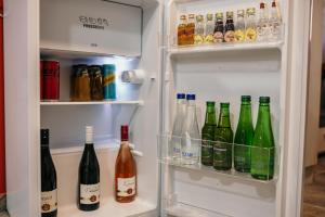 - un réfrigérateur ouvert rempli de nombreuses bouteilles d'alcool dans l'établissement Bordeaux City Center, à Novi Sad